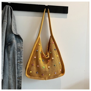 Close-up of yellow knit tote bag with colorful pearl accents and crochet texture details
