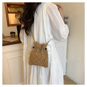 Détail du sac seau ajouré crocheté à la main avec cordon et perles en bois naturel