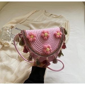 Detailed view of pink woven bucket bag with 3D floral accents and dual-tone fringe tassels