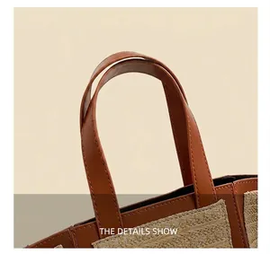 Detail view of woven straw tote bag with brown leather handle and fine stitching detail