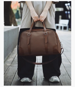 Macro shot of brown leather texture and metal buckle detail on a travel handbag