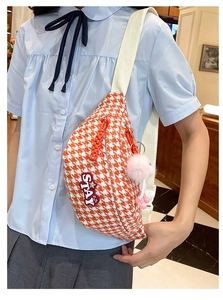 Détail du sac de poitrine à motif pied-de-poule orange avec un écusson décoratif STAY