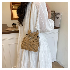 Détail du sac seau marron en tissage évidé fait main avec cordon et perles en bois