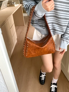 Braune Vintage-Unterarmtasche aus Kunstleder mit silbernen Nieten und breitem Gurt