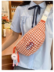 Détail du sac de poitrine orange à motif pied-de-poule avec breloque en peluche