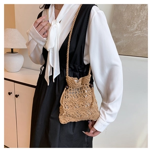 Détail d'un mini sac seau tressé kaki avec fermeture à cordon et perles en bois