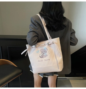 Détail du sac cabas à rayures roses avec ours de dessin animé et boucle argentée