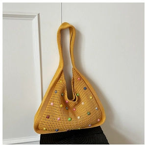 Detail of yellow knit tote bag featuring woven texture and colorful pearl beads
