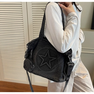 Détail du sac cabas en denim noir délavé avec relief étoile et mini porte-monnaie