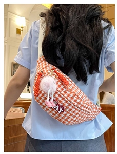 Vue détaillée du sac de poitrine pied-de-poule orange avec patch brodé et pompon