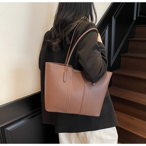 Détail du sac cabas en cuir marron foncé avec texture grainée et longues anses