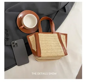 Detail of woven straw tote bag with brown leather trim and dual handles on lifestyle background