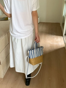 Close-up of blue striped canvas and woven straw texture on the versatile tote bag