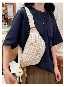 Détail du sac bandoulière pied-de-poule avec écusson STAY et gri-gri monstre jaune