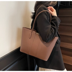 Vue détaillée d'un grand sac cabas en cuir marron avec surpiqûres sur l'épaule