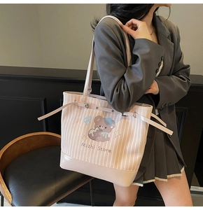 Détail du sac cabas en toile rayée rose avec imprimé ours et bandoulière en cuir