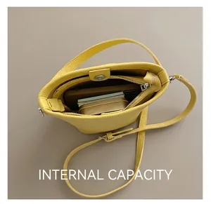Dettaglio dell'interno della borsa a secchiello gialla con chiusura magnetica e pelle
