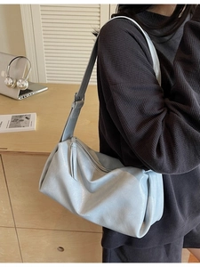 Minimalistische hellblaue Hobo-Schultertasche für Damen aus glänzendem Leder am Modell