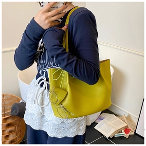 Detailed view of yellow lychee pattern leather tote bag in a casual lifestyle setting