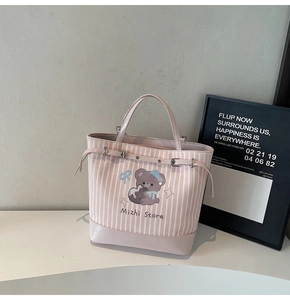 Détail du sac cabas en toile avec rayures roses, imprimé ours et boucle en métal doré