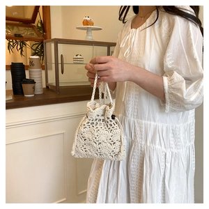 Gros plan sur le sac seau au crochet fait main avec texture délicate en maille ajourée beige