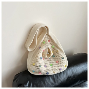 Detail of hollow knit tote bag with rainbow pearl embellishments and wide shoulder strap
