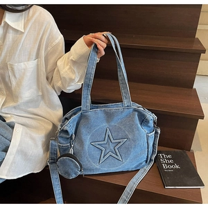 Détail du sac cabas en jean bleu délavé avec étoile en relief et mini pochette ronde