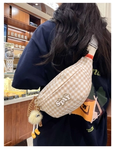 Détail du sac bandoulière à motif pied-de-poule avec charm en peluche dans un café
