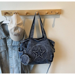 Detail of blue washed denim tote bag with star patch and mini coin purse attachment