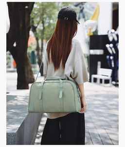Outdoor view showing the large mint green travel bag with adjustable shoulder straps