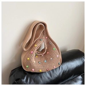 Detail of knit beach tote with colorful translucent beads on beige crochet fabric