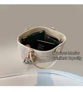 Top view of beige textured tote bag showing spacious interior with cute teddy bear charm
