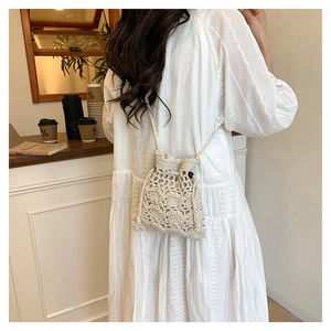 Détail du motif floral ajouré au crochet sur un sac seau à cordon couleur crème