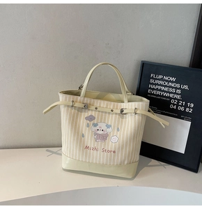 Détail du sac cabas en toile avec motif rayé, imprimé animal et fermeture à boucle en métal