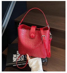 Détail du sac seau rouge tissé avec texture en cuir PU et bandoulière réglable