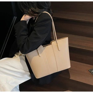 Détail du sac cabas beige avec texture à grain fin et coutures verticales élégantes
