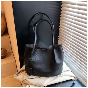 Detail of black lychee grain tote bag with micro charm pouch and long shoulder straps