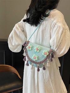 Blue hand-woven bucket bag with crochet floral decorations and tassels for summer beach wear