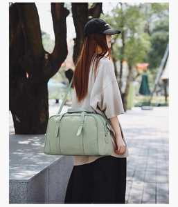 Detail of mint green travel bag featuring silver buckles and durable reinforced handles