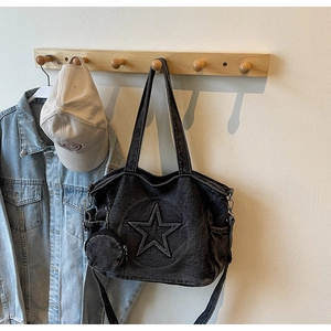 Détail du sac cabas en denim noir avec surpiqûres étoiles et porte-monnaie rond amovible
