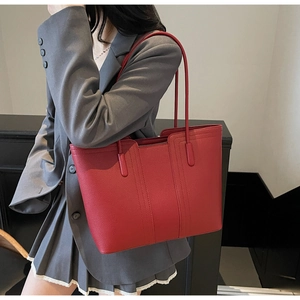 Gros plan sur un cabas rouge vif en cuir grainé avec des détails de coutures élégantes