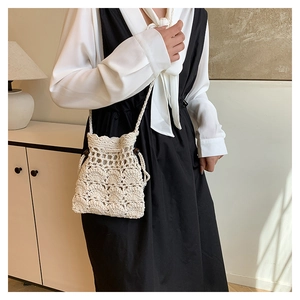 Détail du sac seau au crochet crème avec cordon de serrage et perles en bois