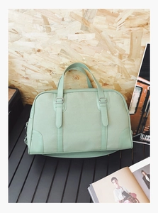 Macro shot of mint green canvas texture and silver metal buckles on a Boston handbag