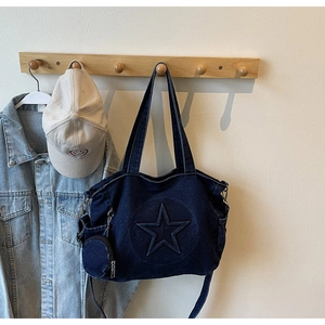 Detailansicht der blauen Denim-Tasche mit Stern-Relief und passender runder Münztasche