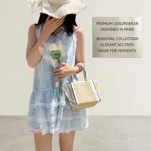 Detail of light blue sleeveless dress featuring tiered white lace layers and butterfly print