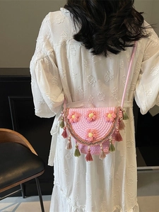 Pink woven bucket bag with 3D crochet flowers and tassels for summer beach vacation wear