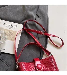 Détail de la texture tissée rouge sur le sac seau avec bandoulière réglable et boucle argent