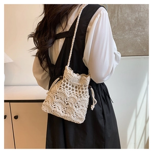 Détail du sac seau crocheté à la main avec cordon et perles en bois en crème