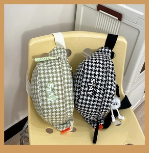 Détail de sacs bandoulière à motif pied-de-poule avec logo STAY et étiquette orange