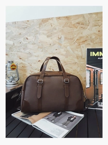 Detail of premium brown faux leather travel bag with vintage metallic buckle and texture